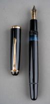 A Montblanc black fountain pen with gilt fittings, the 14c gold nib stamped MONT BLANC twice and 14C