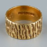 An 18ct gold ring, 9mm wide textured band, size L, gross weight approx 6.2g Good condition, wear
