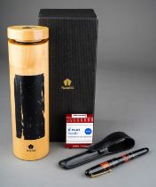 A Japanese Namiki red and gold lacquer fountain pen, the barrel and cover with red flower and