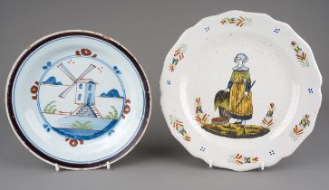 An early 18th Century Delftware dish, the centre painted with a windmill with foliage and rockery