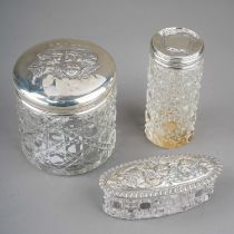 Three early 20th Century silver mounted cut glass dressing table bottles / jars, two covers chased