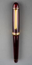 A Japanese Platinum burgundy and gilt transparent fountain pen, the nib stamped #3776 P 14K MUSIC