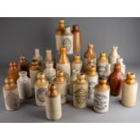 Twenty-eight various stoneware beer and water bottles, some all cream, most with black transfer