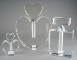 A collection of three various glass scent bottles to include large heart shaped, small heart