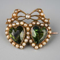 A Victorian yellow metal double heart brooch, set with heart-shaped green paste stones, within a