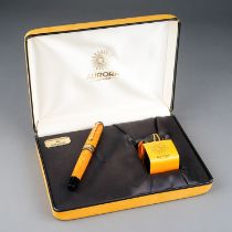 An Italian Aurora amber marbled fountain pen with 18Kt gold nib, stamped 18K 750, the cover with