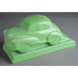 A Dartmouth style desk model of ceramic green Morris Minor 1000 on separate stand with recess for