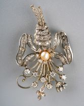 A white gold and diamond spray brooch, the bouquet of flowers tied with a pearl-set ribbon, set