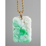A Chinese carved jade pendant, on a 9ct gold rope twist chain, total gross weight approx 32.5g (gold