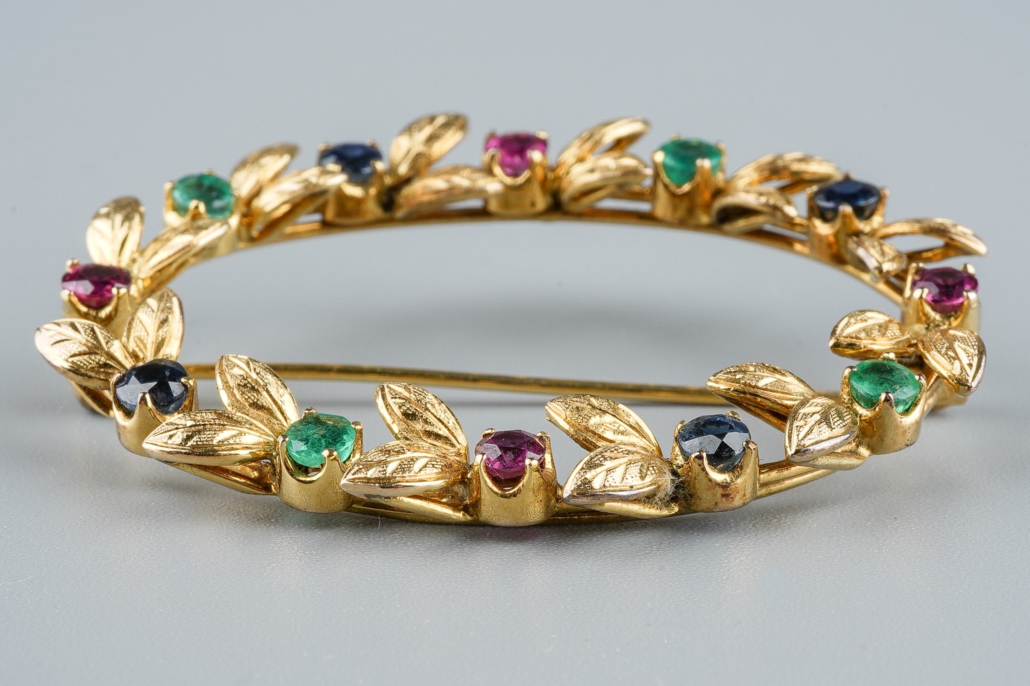 A yellow gold and gem-set oval brooch, set with rubies, emeralds and sapphires, approx 4.5cm wide, - Image 2 of 3