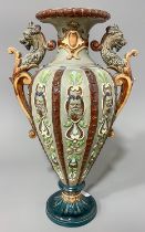 A late 19th Century Majolica two handled vase, the sided with moulded strapwork with mask terminals,