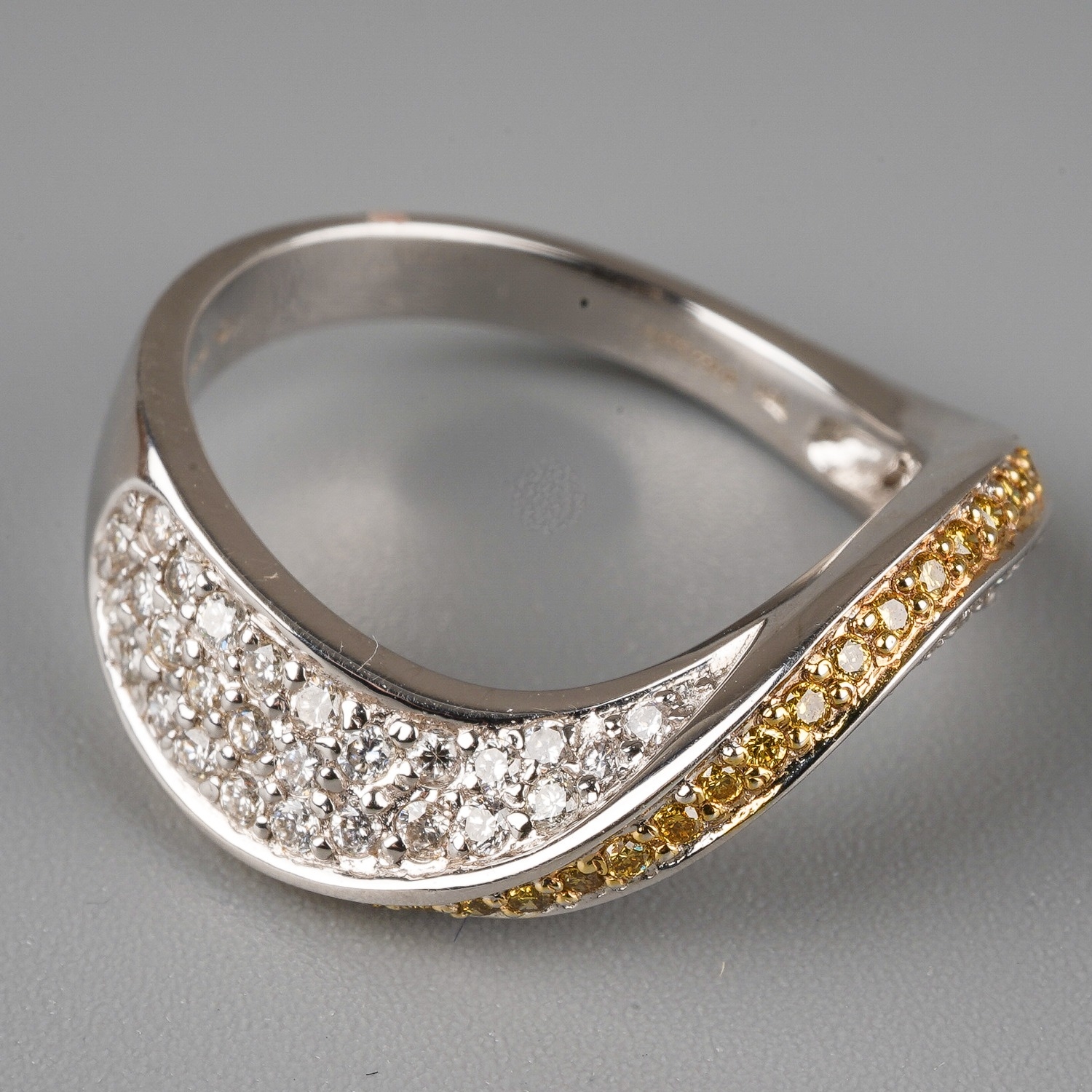 An 18ct white gold yellow and white diamond dress ring, set with a wave of yellow round-brilliant