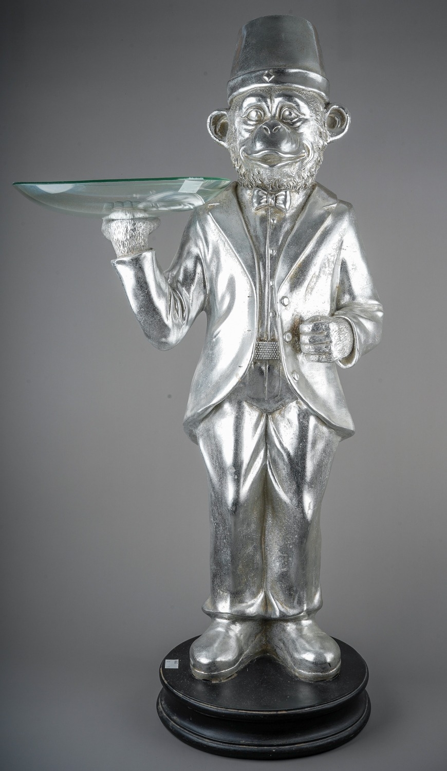 A floor standing silvered figure of dressed monkey with glass bowl in right hand (Butler tray), 82cm