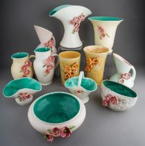 A collection of Bretby Posies, including jugs, bowls, basket and vases, applied with flowers,