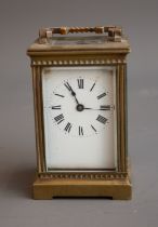 An early 20th Century gilt metal mounted carriage clock, white enamel dial with Roman numerals,