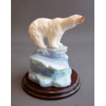 A 20th Century ceramic model of a polar bear on icy plinth, unmarked, with wooden circular stand