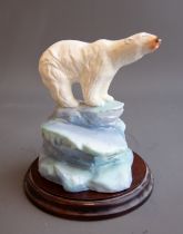 A 20th Century ceramic model of a polar bear on icy plinth, unmarked, with wooden circular stand