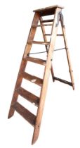 A vintage 6 rung Simplex wooden step ladder, cast iron supports and central supports, approx 142cm