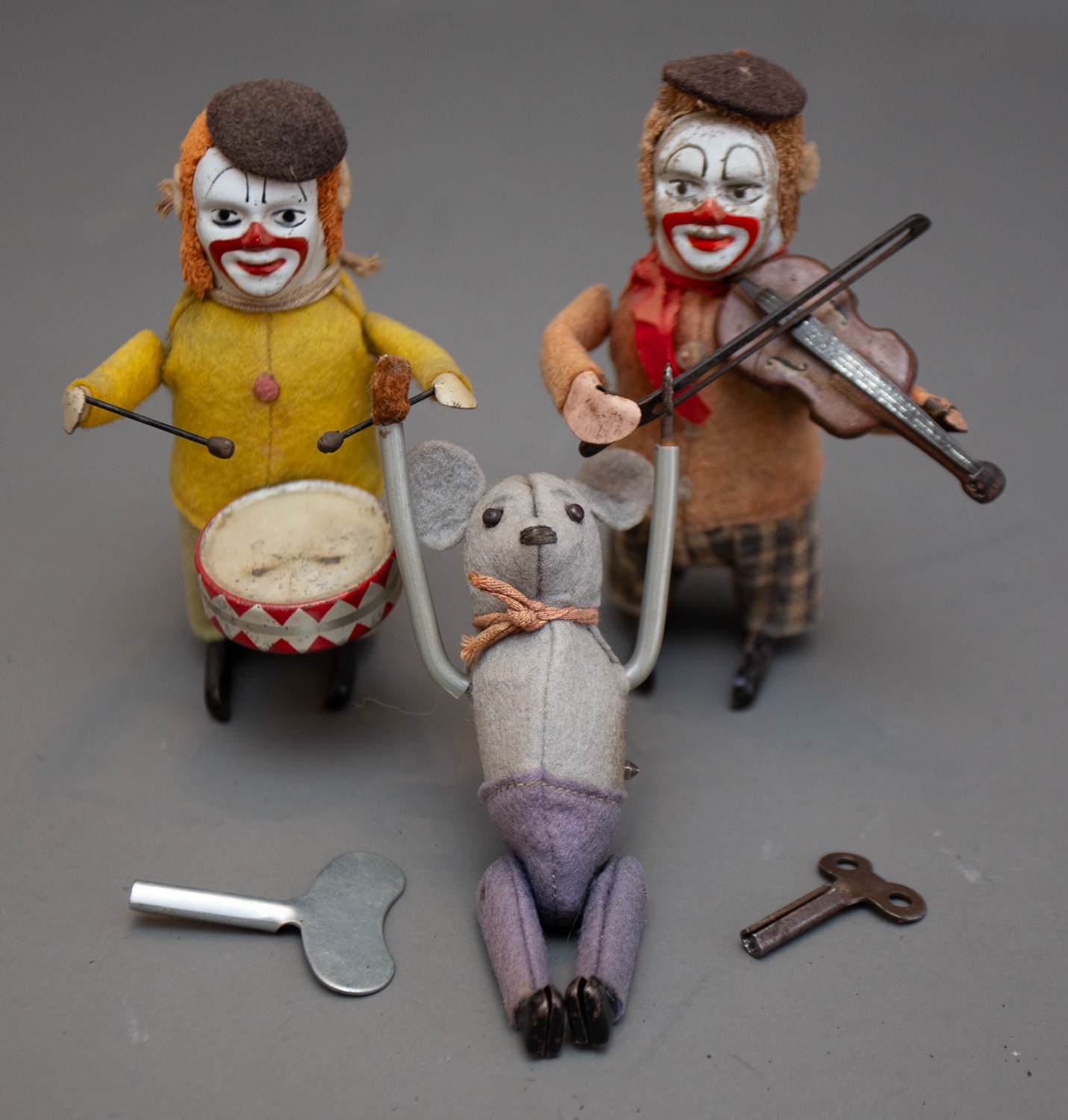 Three vintage Schuco (German) tinplate wind up clockwork toys to include: Drummer Clown wearing ocre