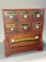 A Reproduction Apothecary chest of six short and one long drawer on bracket feet, with brass style