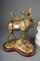 A gilt metal model of a Stag on shaped base together with a Modern brass figure of a girl playing