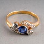 An early 20th century sapphire and diamond ring, set with a sapphire flanked by two old-cut