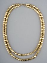 A yellow gold double strand necklace, two rows of beads, the larger approx 7mm the smaller approx