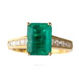 An 18k yellow gold emerald and diamond ring