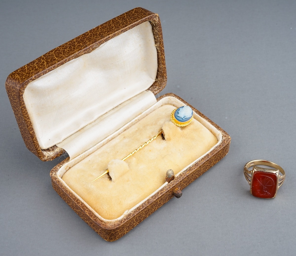 A late 19th/early 20th century yellow gold cameo stick pin, set with an oval blue and white glass