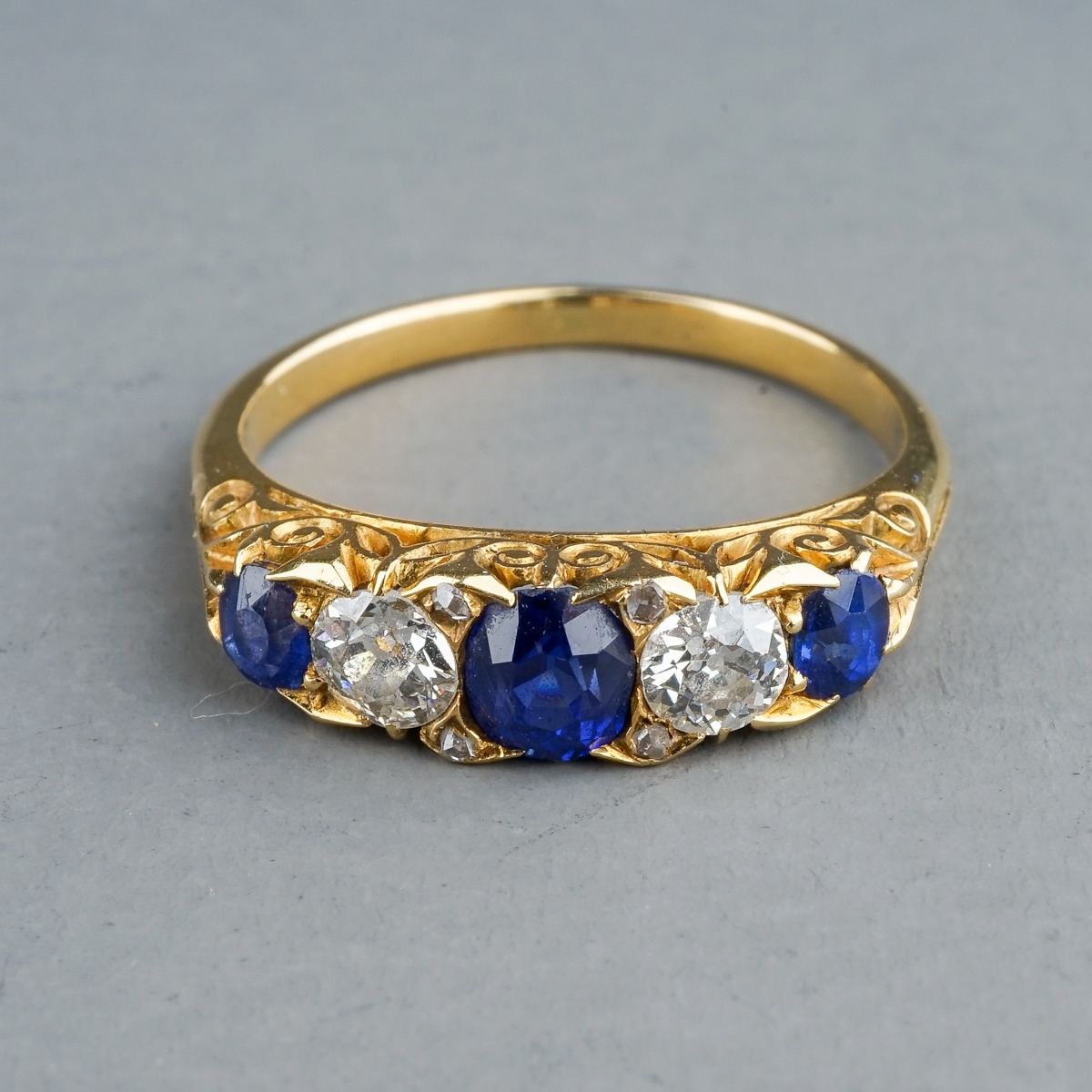 An Edwardian yellow gold sapphire and diamond five-stone ring, size L, unmarked assessed as approx