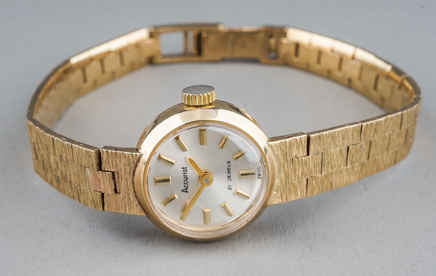 A ladies Accurist 9ct gold wristwatch, with integral bracelet 9ct gold bark effect strap, total