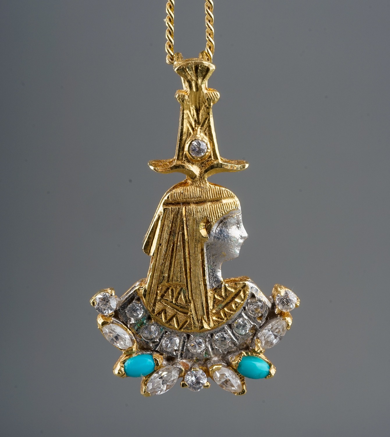 An Egyptian yellow metal and paste pendant necklace, cast as a pharoah with paste and turquoise