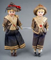 A pair of early 20th Century small dolls dressed as a Sailor Boy and Girl, both with porcelain