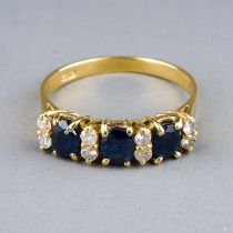 An 18ct yellow gold sapphire and diamond ring, set with three oval-cut sapphires and eight round