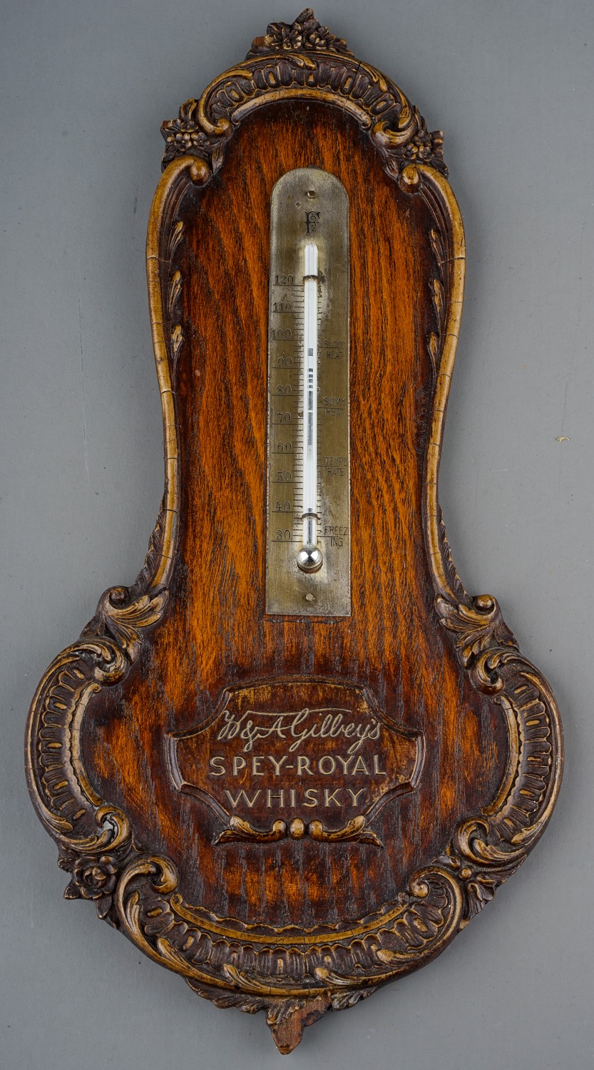 A 20th Century Gilbey's Spey-Royal Whiskey wall thermometer, with carved borders, approx 34cm long