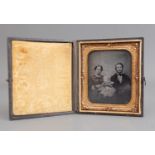 A Victorian Daguerreotype depicting a Mother and Father with their baby within gilt metal frame,