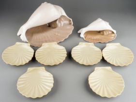 Two Retro Poole pottery models of conch shells together with earthenware scallop dishes