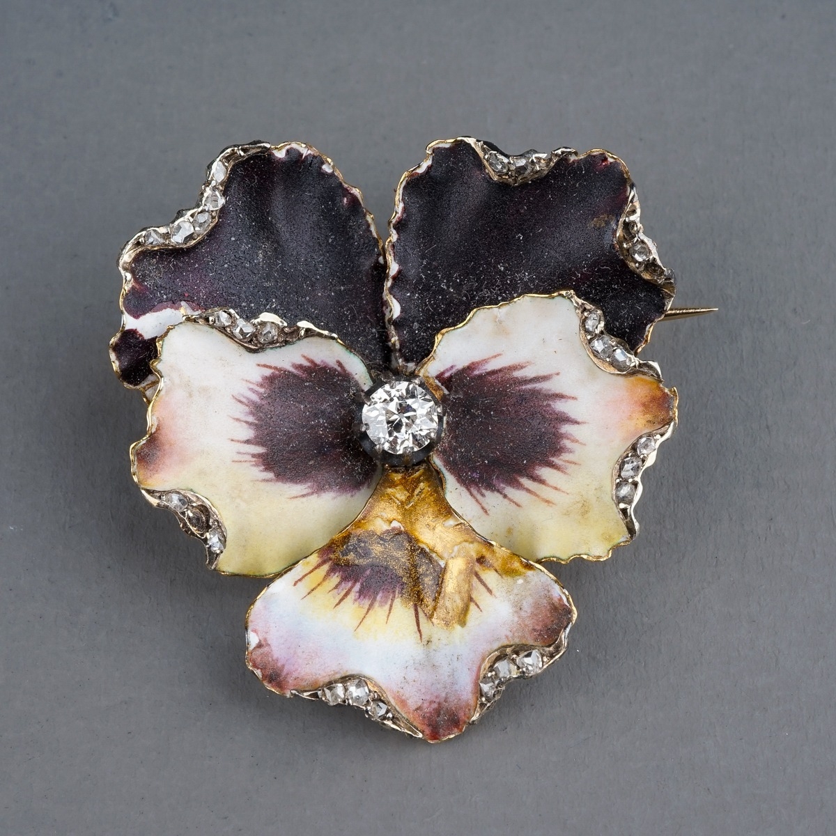 A Victorian enamel and diamond pansy brooch, set with an old-cut diamond in polychrome enamel