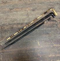 Three antique eastern walking sticks - ebonised sword stick, ebony elephant stick and horn