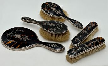 Five piece silver and tortoiseshell pique work dressing set, comprising four brushes and a hand