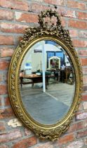 Late 19th century continental gilt wood and gesso oval wall mirror, mounted by plaster work wreath