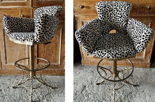 A pair of upholstered leopard print adjustable bar stools on fancy gilt metal frames. Height 97cm