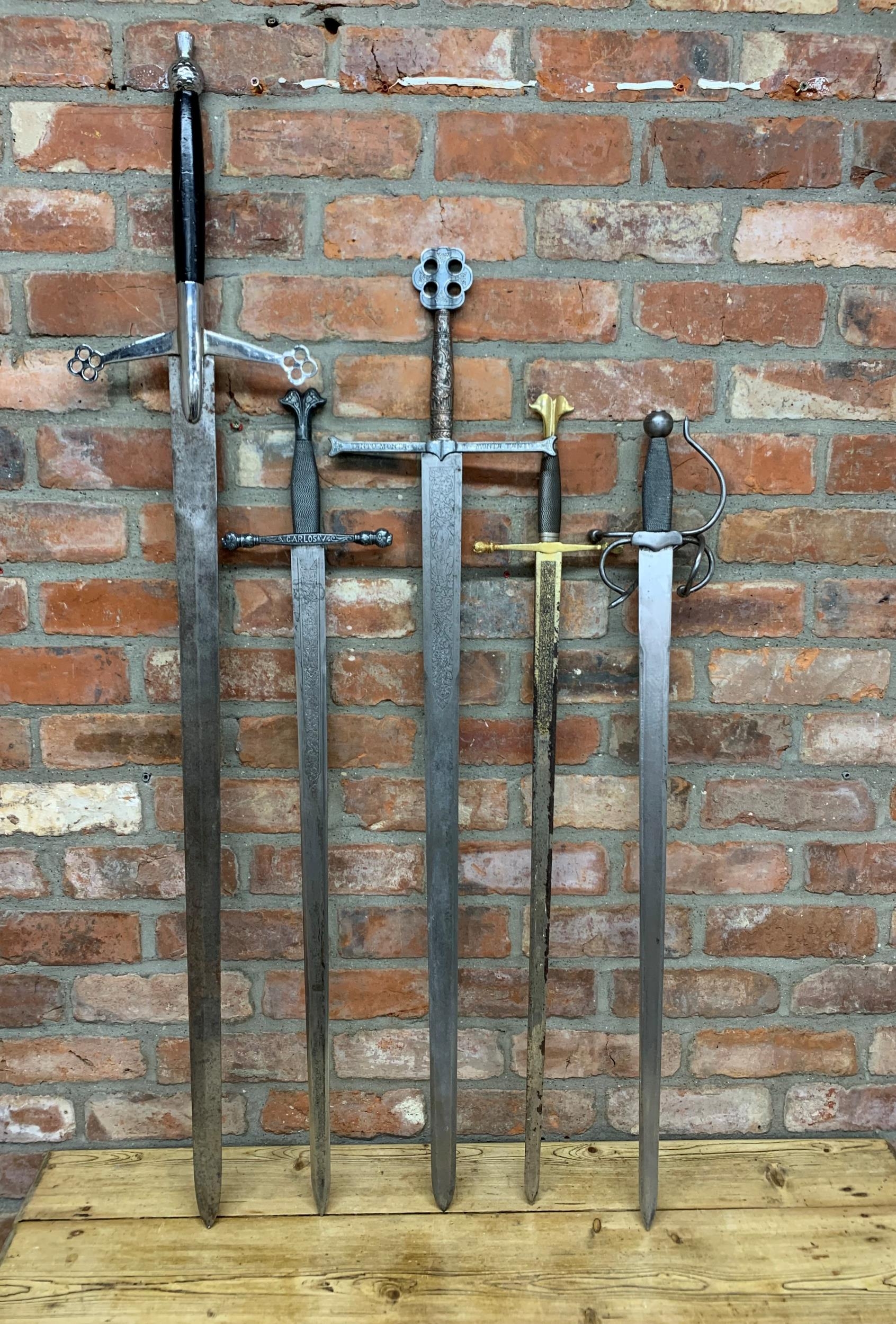 Four replica broadswords / claymores, one marked 'Toledo made in Spain' together with a replica '