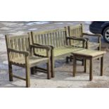 A weathered teak garden suite with slatted seats and backs to include two armchairs, a bench and a