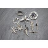 Ten silver brooches to include Scottish examples, 73.6g, within Morocco leather case