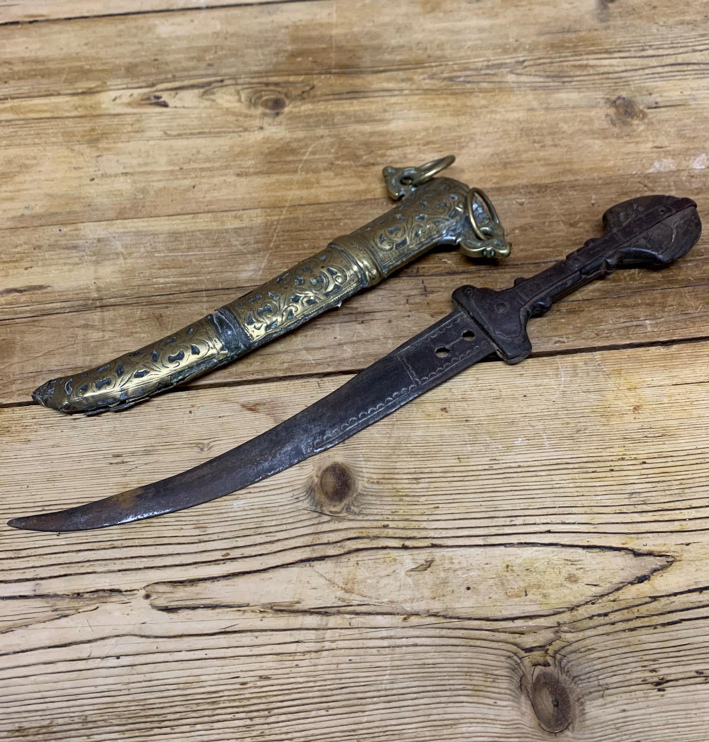 19th century Jambiya dagger with iron blade and carved wooden hilt, held in a decorative scrolled - Image 2 of 4