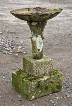 Weathered four piece stone garden bird bath with stepped base and tapered column, H 74cm