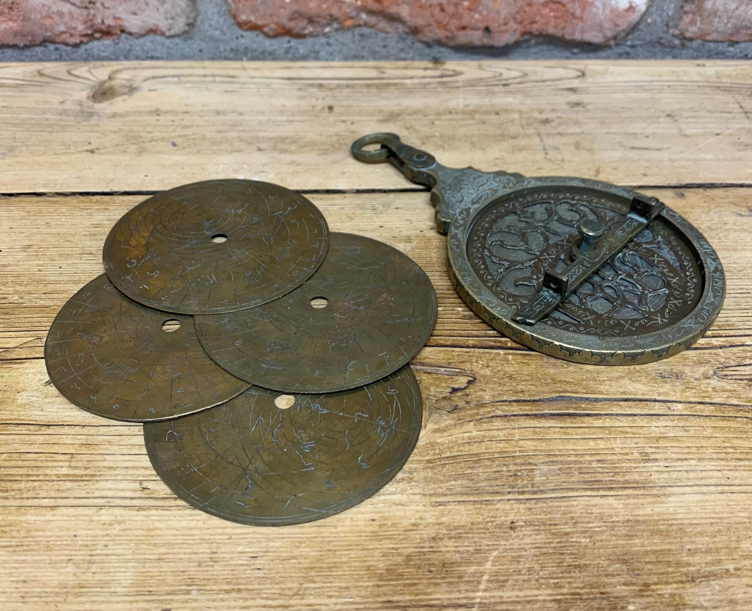 Antique Islamic brass astrolabe instrument, engraved throughout having pierced rete, four doubled