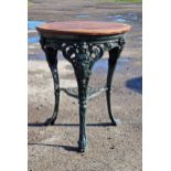 A Victorian painted cast iron Britannia pub table with pierced undershelf and circular wooden top, H