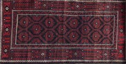 Persian Meshad Belouch rug with geometric red decoration on black ground, 220 x 115cm